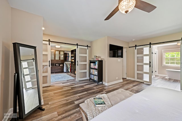 7500 US Highway 34, Oswego, IL 60543 - living area with a barn door, a ceiling fan, wood finished floors, and baseboards