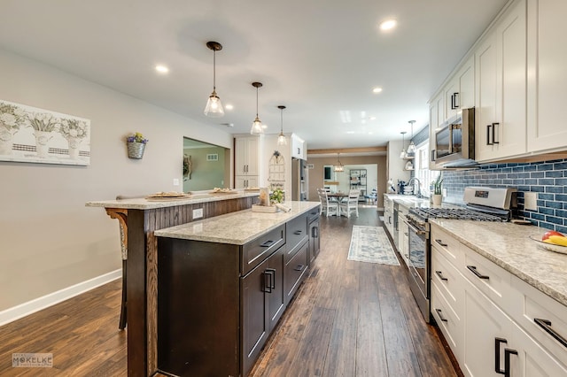 7500 US Highway 34, Oswego, IL 60543 - kitchen featuring stainless steel appliances, a kitchen island, a kitchen bar, dark wood-type flooring, and recessed lighting
