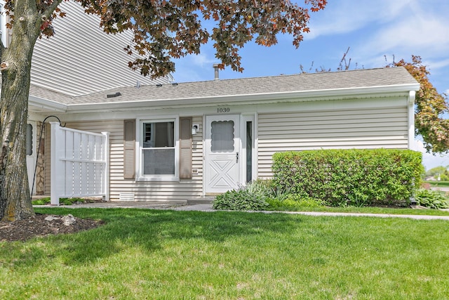 single story home with a front lawn and roof with shingles
