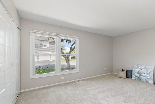 carpeted spare room featuring baseboards