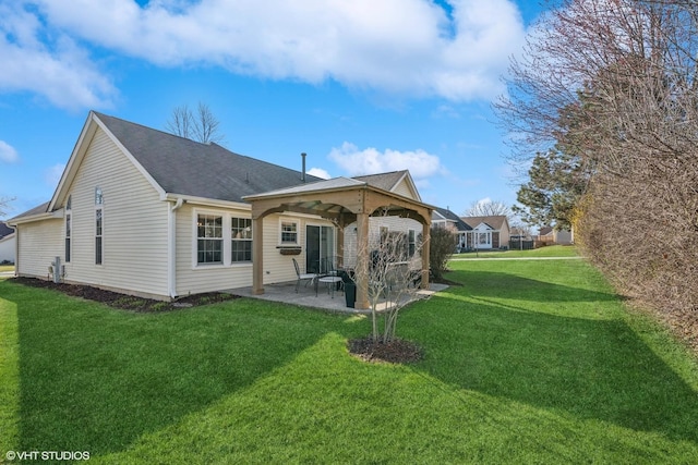rear view of property with a gazebo, a patio, a lawn, and roof with shingles