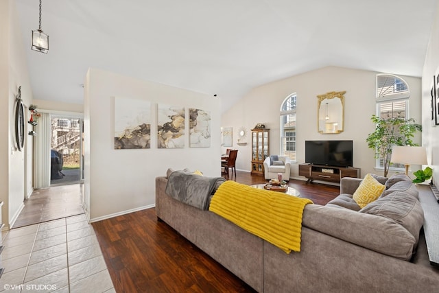 living area with lofted ceiling, wood finished floors, and baseboards