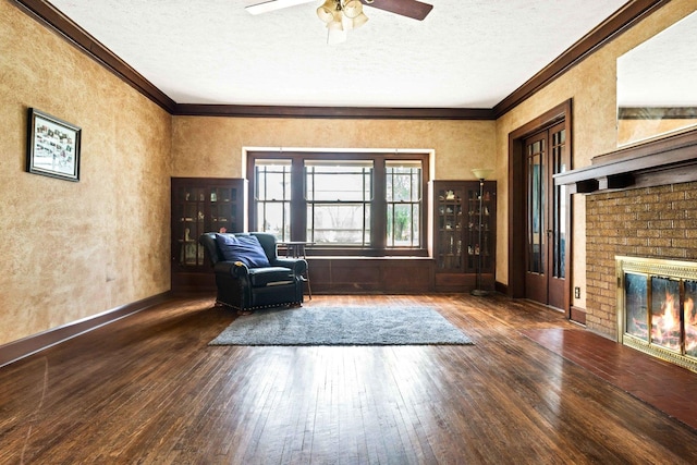 546 Elmwood Ct, El Paso, IL 61738 - living area featuring wood-type flooring, a textured ceiling, ornamental molding, ceiling fan, and a brick fireplace