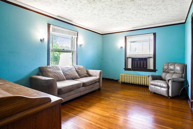 546 Elmwood Ct, El Paso, IL 61738 - living room featuring radiator heating unit, crown molding, healthy amount of natural light, hardwood / wood-style floors, and a textured ceiling