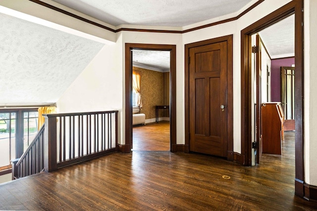 546 Elmwood Ct, El Paso, IL 61738 - hallway featuring a textured ceiling, radiator heating unit, wood finished floors, crown molding, and an upstairs landing