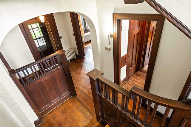 546 Elmwood Ct, El Paso, IL 61738 - staircase featuring arched walkways, radiator, and wood finished floors