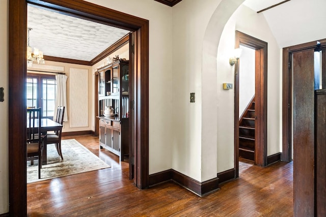546 Elmwood Ct, El Paso, IL 61738 - hall featuring arched walkways, dark wood-style flooring, baseboards, crown molding, and stairs