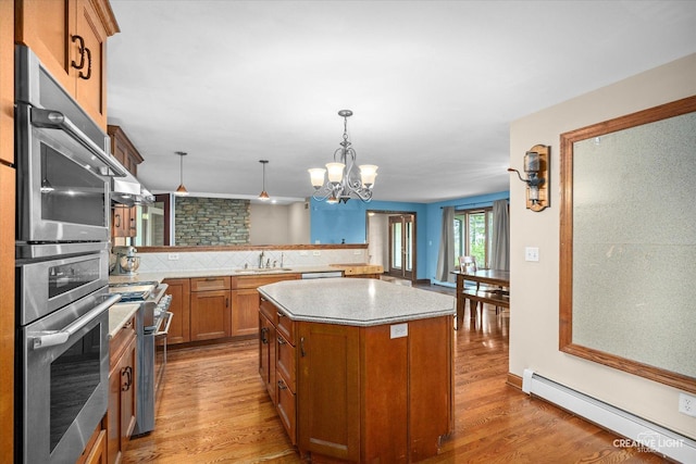 45W251 Ic Trl, Maple Park, IL 60151 - kitchen with a baseboard radiator, stainless steel appliances, a sink, brown cabinets, and a center island