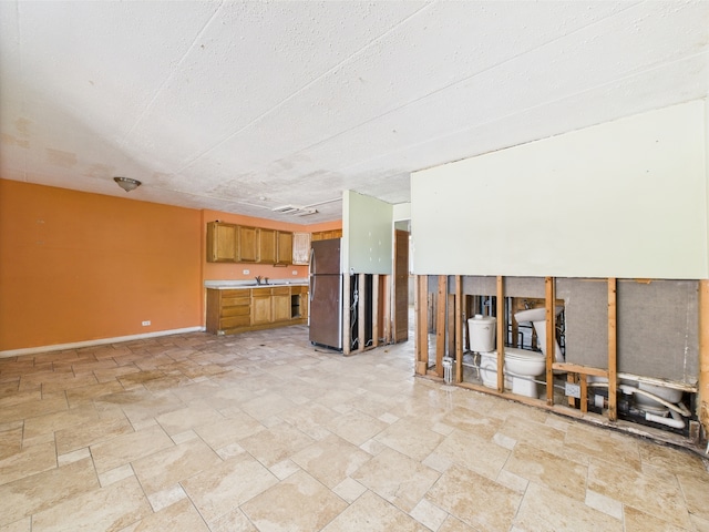 10033 Irving Park Rd Unit 1A, Schiller Park, IL 60176 - unfurnished living room featuring light stone finish floors and baseboards