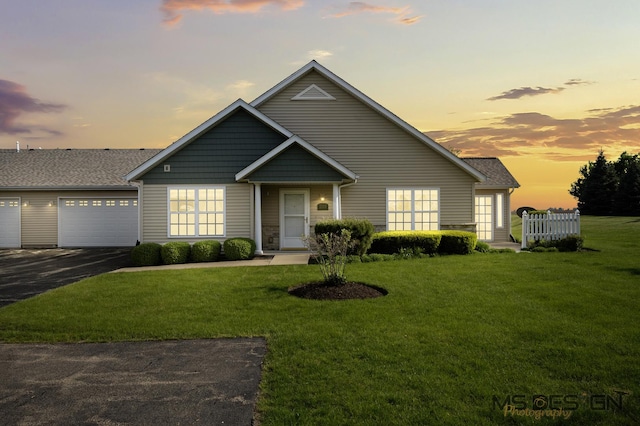 traditional-style home featuring a front yard, asphalt driveway, and roof with shingles