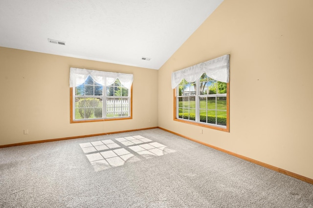 carpeted spare room with baseboards and lofted ceiling