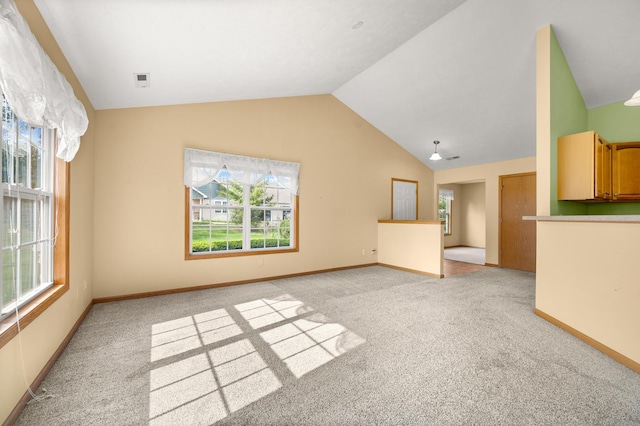 unfurnished living room with light carpet, plenty of natural light, lofted ceiling, and baseboards