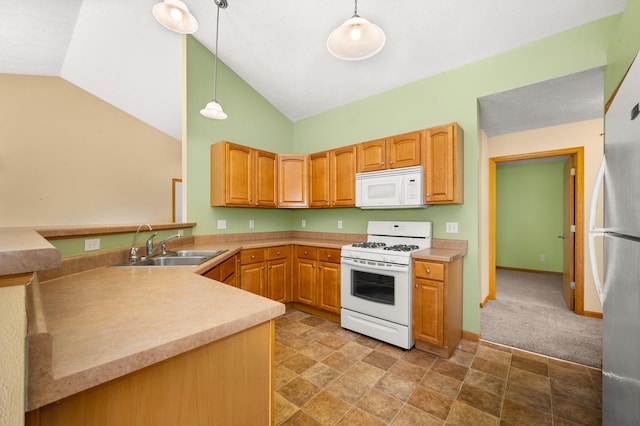 kitchen featuring white appliances, decorative light fixtures, light countertops, a sink, and high vaulted ceiling