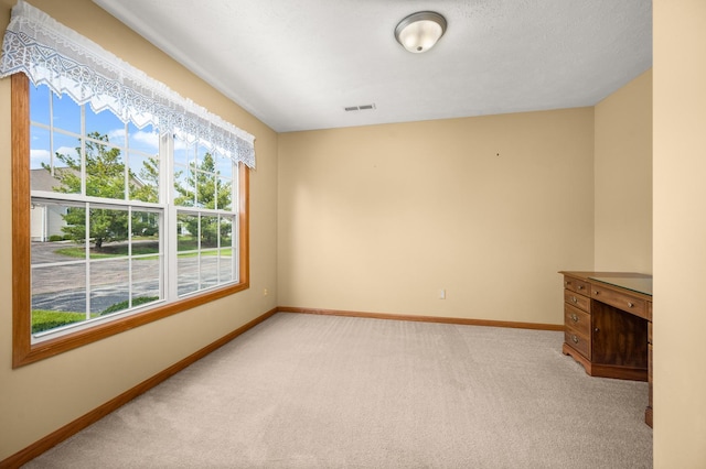 empty room with baseboards and light carpet