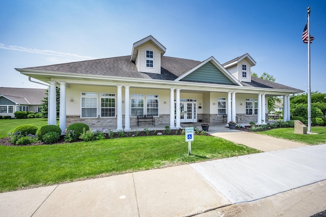 view of front of house with french doors, a porch, stone siding, and a front lawn