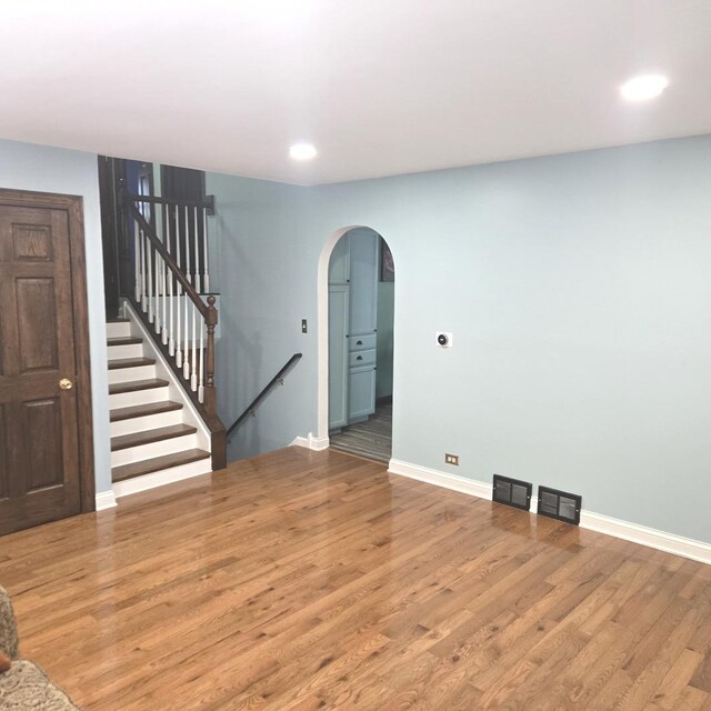 2810 Brentwood Ln, Mchenry, IL 60050 - unfurnished living room featuring arched walkways, wood finished floors, recessed lighting, and stairway