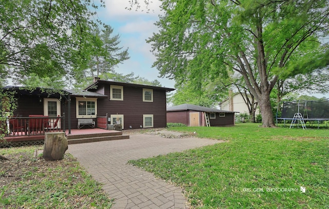 2810 Brentwood Ln, Mchenry, IL 60050 - rear view of house featuring a trampoline, a deck, an outbuilding, and a lawn
