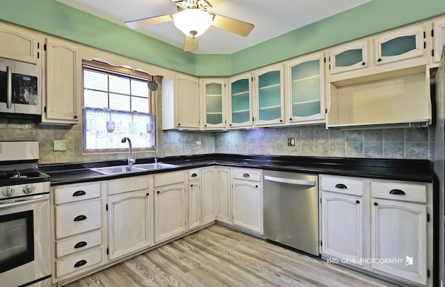 2810 Brentwood Ln, Mchenry, IL 60050 - kitchen with stainless steel appliances, a sink, dark countertops, light wood-style flooring, and a ceiling fan