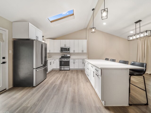 1150 Jerald Dr, Joliet, IL 60431 - kitchen with stainless steel appliances, a kitchen bar, light countertops, light wood-style flooring, and lofted ceiling