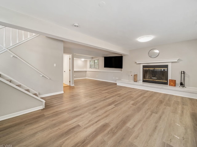 1150 Jerald Dr, Joliet, IL 60431 - unfurnished living room featuring stairway, wood finished floors, baseboards, and a glass covered fireplace