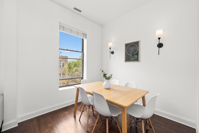 dining room with baseboards and dark wood-type flooring