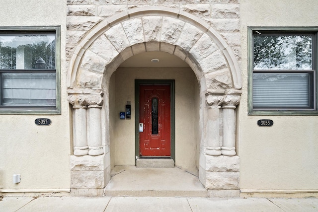 property entrance featuring stone siding and stucco siding