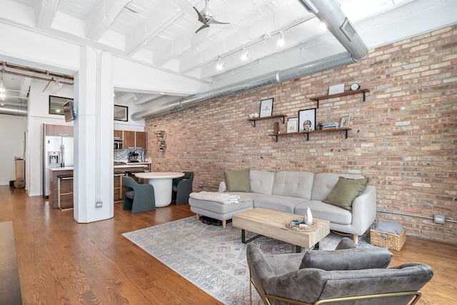 living room featuring wood finished floors and brick wall