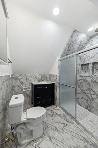6748 S Wabash Ave, Chicago, IL 60637 - full bathroom featuring toilet, tile walls, marble finish floors, a shower stall, and recessed lighting