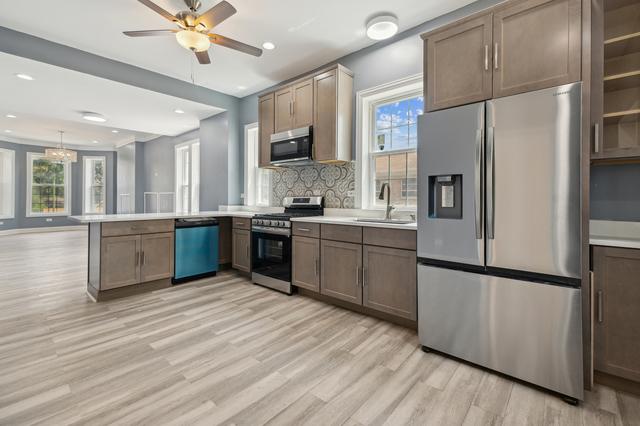 6748 S Wabash Ave, Chicago, IL 60637 - kitchen featuring appliances with stainless steel finishes, a peninsula, light wood finished floors, a sink, and recessed lighting