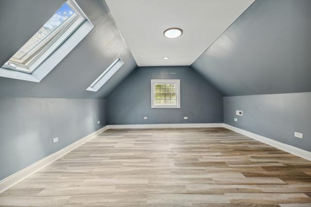 6748 S Wabash Ave, Chicago, IL 60637 - bonus room with a skylight, wood finished floors, lofted ceiling, and baseboards