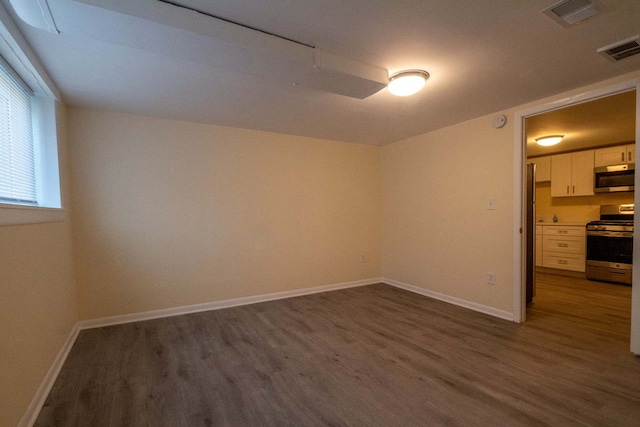 empty room with dark wood-type flooring and baseboards