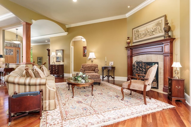 5344 River Run Parkway, Belvidere, IL 61008 - living area featuring arched walkways, wood finished floors, ornate columns, a fireplace, and crown molding