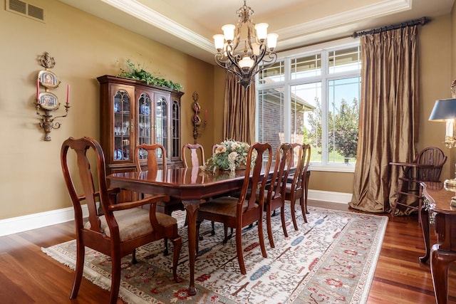 5344 River Run Parkway, Belvidere, IL 61008 - dining space with a chandelier, crown molding, baseboards, a raised ceiling, and wood finished floors