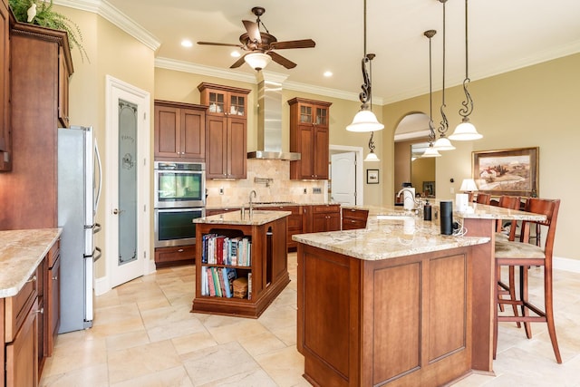 5344 River Run Parkway, Belvidere, IL 61008 - kitchen featuring stainless steel appliances, a large island with sink, ceiling fan, brown cabinetry, and ornamental molding