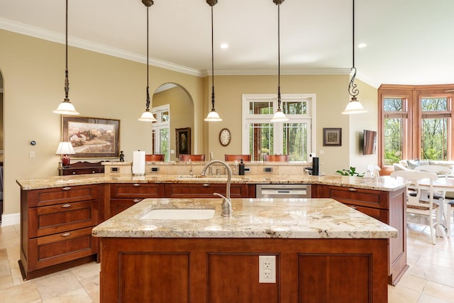 5344 River Run Parkway, Belvidere, IL 61008 - kitchen featuring a large island with sink, arched walkways, a sink, ornamental molding, and brown cabinets