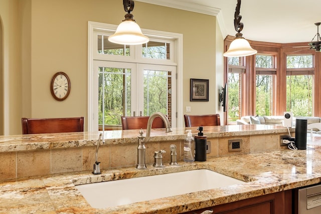 5344 River Run Parkway, Belvidere, IL 61008 - kitchen with a sink, hanging light fixtures, light stone counters, and ornamental molding