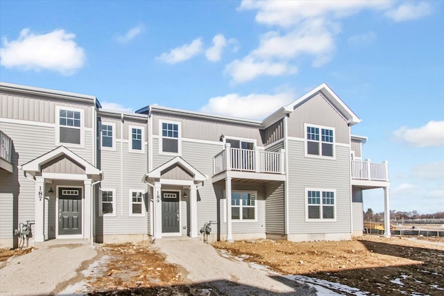 townhome / multi-family property featuring a balcony and board and batten siding