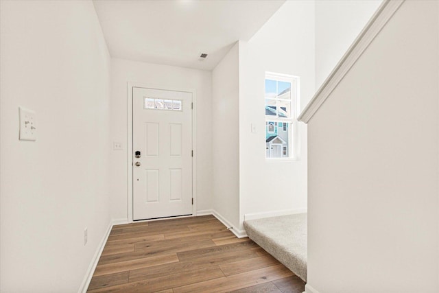 doorway to outside featuring light wood finished floors and baseboards