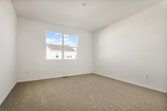 unfurnished room with carpet and baseboards
