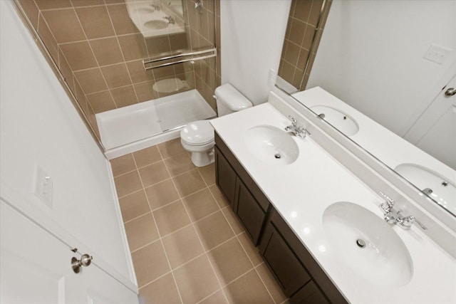 full bath featuring toilet, a shower stall, double vanity, and tile patterned floors