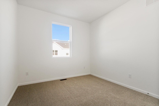 carpeted spare room featuring baseboards