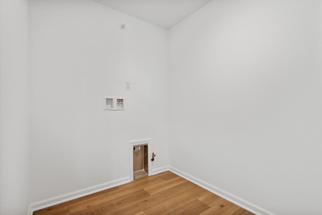 clothes washing area featuring hookup for a washing machine, light wood-style floors, and baseboards