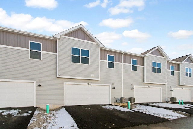 view of front facade with an attached garage, driveway, and board and batten siding