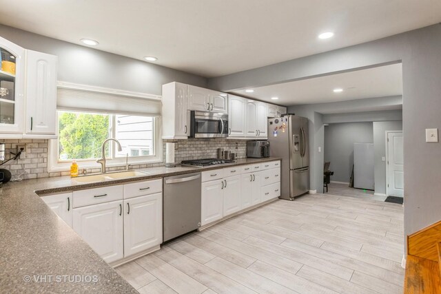 6N715 Gates Ave, Itasca, IL 60143 - kitchen with stainless steel appliances, a sink, white cabinets, glass insert cabinets, and decorative backsplash