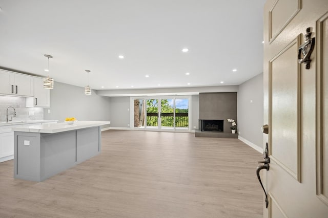 3851 Mission Hills Rd Unit 409, Northbrook, IL 60062 - kitchen featuring a kitchen island, light wood finished floors, light countertops, recessed lighting, and backsplash