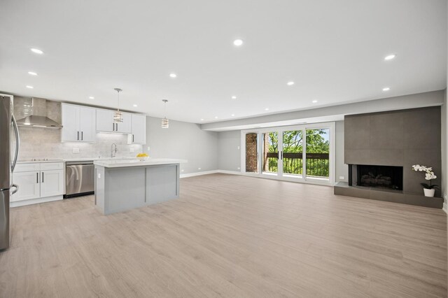 3851 Mission Hills Rd Unit 409, Northbrook, IL 60062 - unfurnished living room with light wood-type flooring, recessed lighting, and a tile fireplace