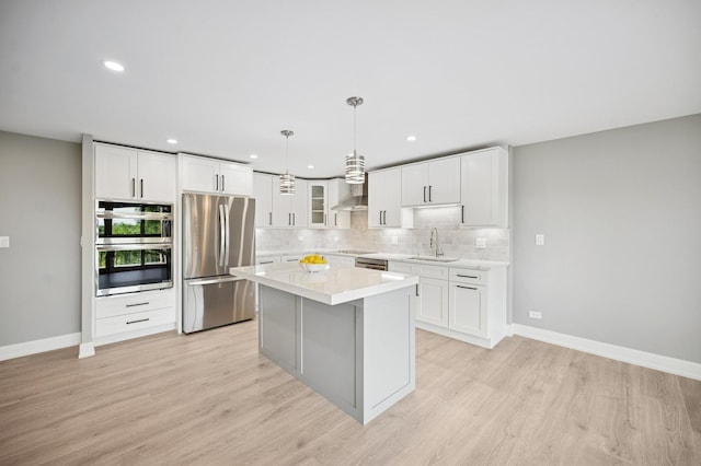 3851 Mission Hills Rd Unit 409, Northbrook, IL 60062 - kitchen with appliances with stainless steel finishes, a center island, decorative backsplash, light countertops, and light wood-style floors