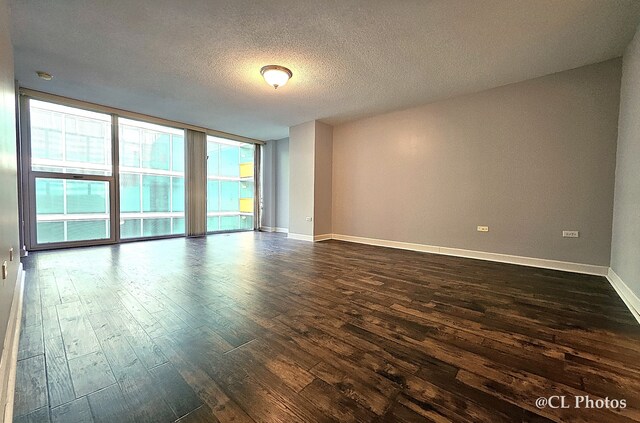 1580 Sherman Ave Unit 1005, Evanston, IL 60201 - unfurnished room featuring dark wood-style floors, baseboards, a wall of windows, and a textured ceiling