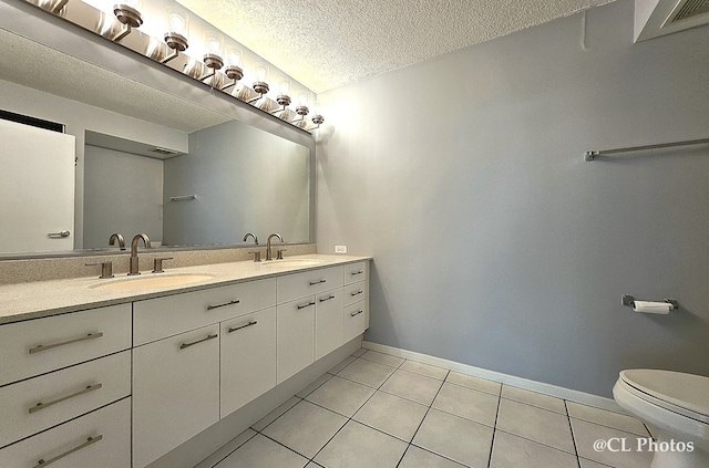 1580 Sherman Ave Unit 1005, Evanston, IL 60201 - bathroom with tile patterned floors, toilet, double vanity, a textured ceiling, and baseboards