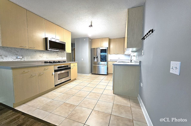 1580 Sherman Ave Unit 1005, Evanston, IL 60201 - kitchen featuring appliances with stainless steel finishes, tasteful backsplash, a sink, light tile patterned floors, and baseboards
